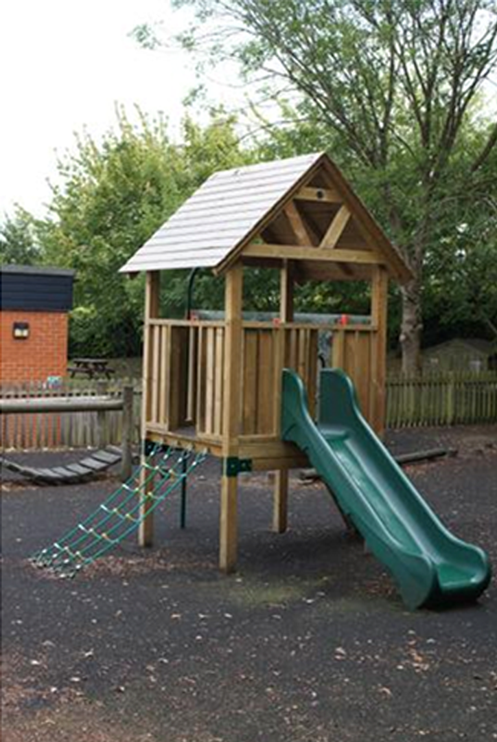 A playground set with climbing wall and slide.